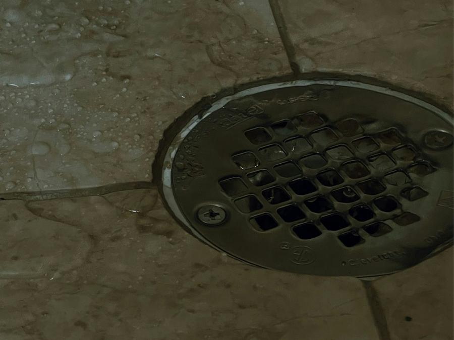 Coladera de drenaje en el piso de un baño